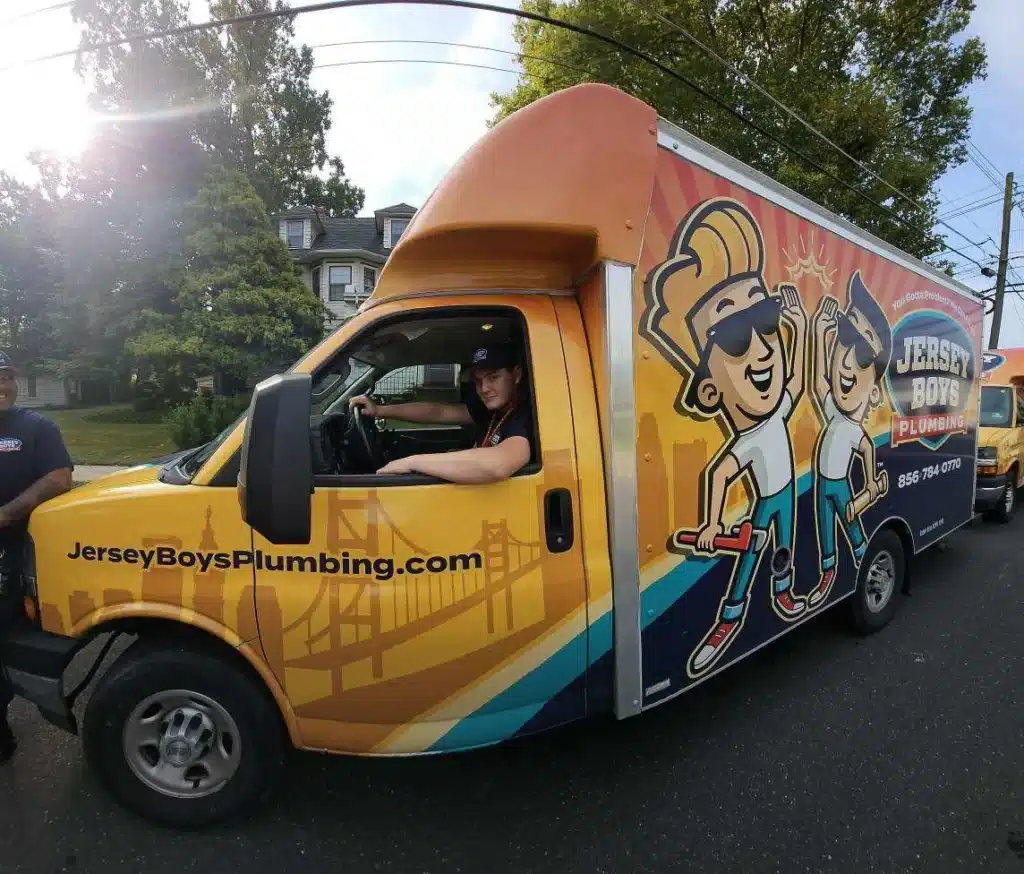 Technician smiling in Jersey Boys Plumbing truck
